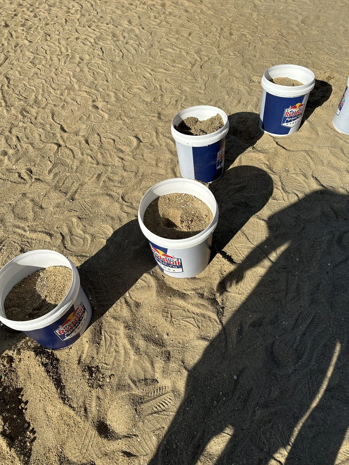 砂を入れたバケツが砂浜に並んでいる